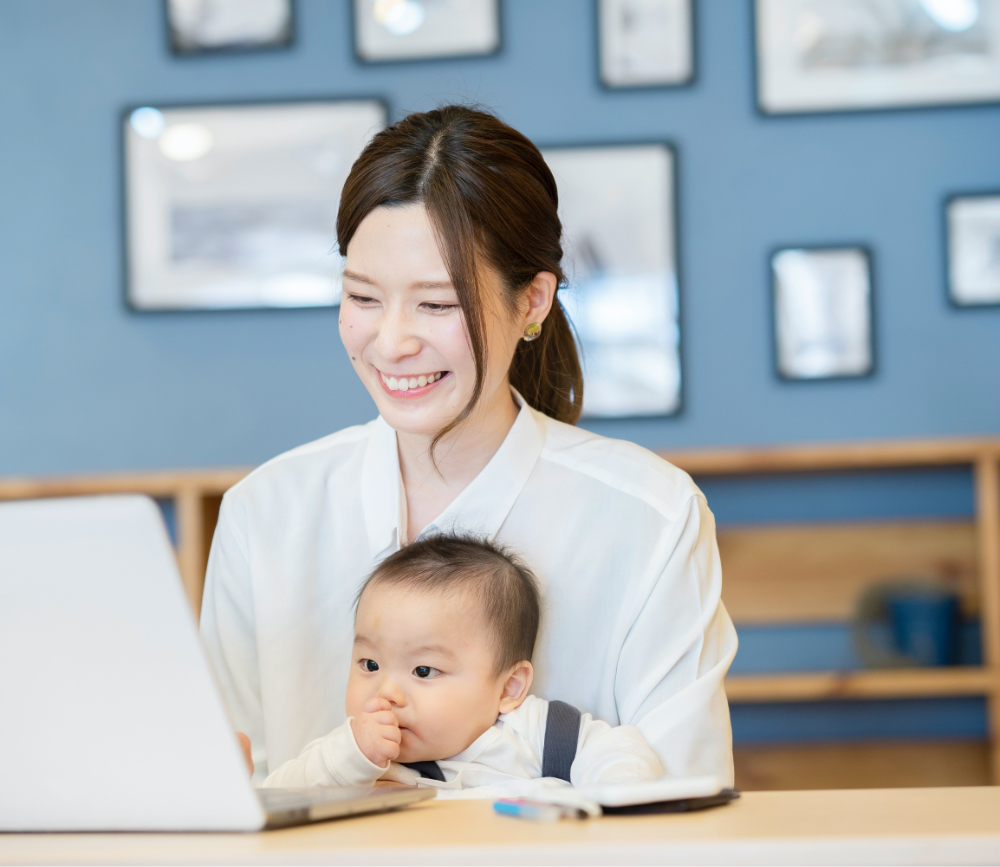 women smiling holding baby looking at laptop testimonials